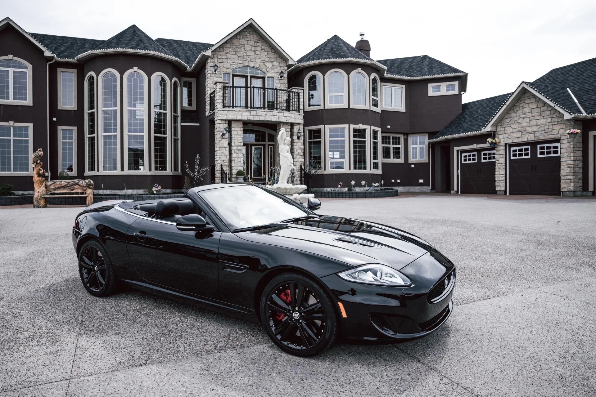 A black convertible parked in the driveway of a large Arizona home.