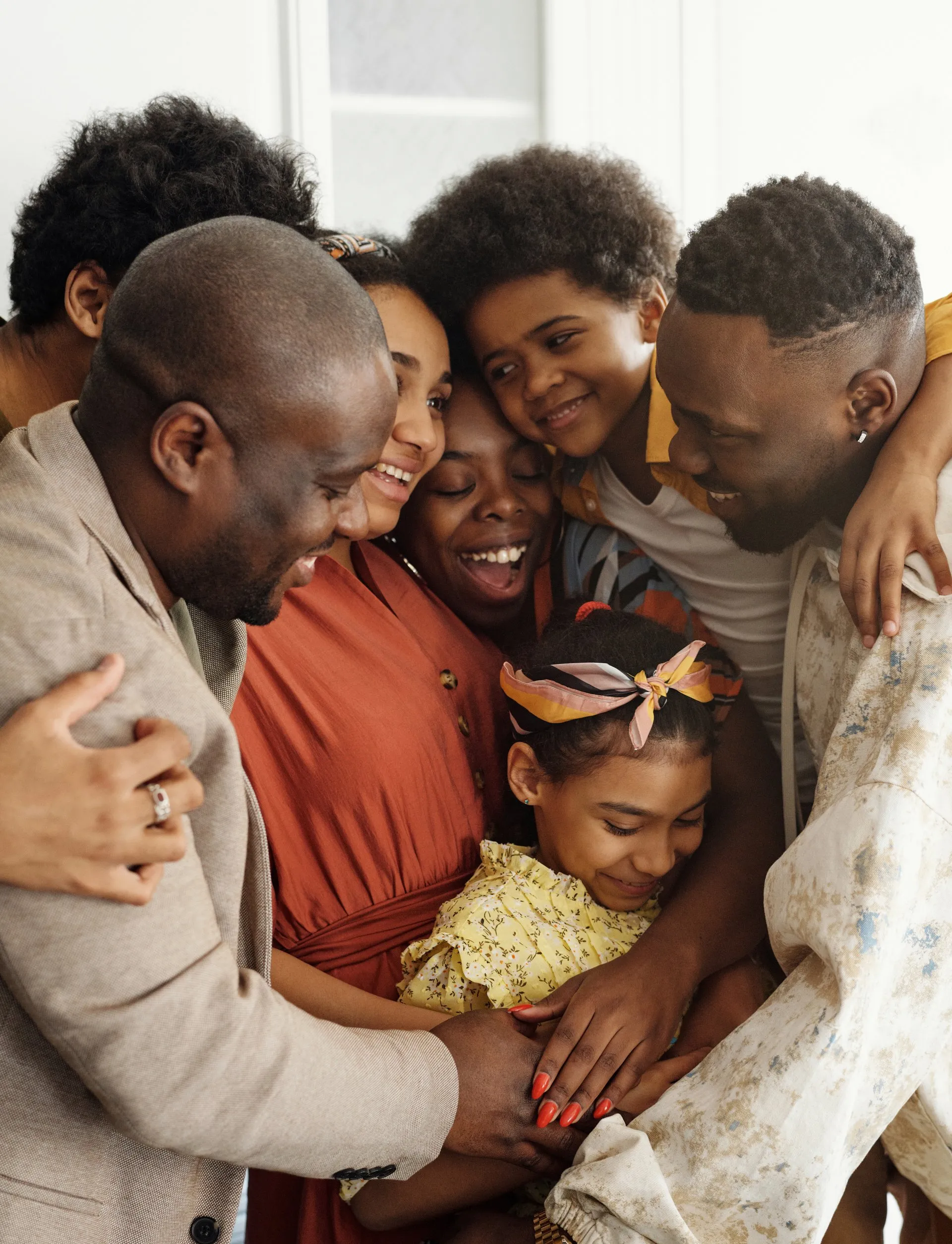 A multigenerational family sharing a joyful group hug.
